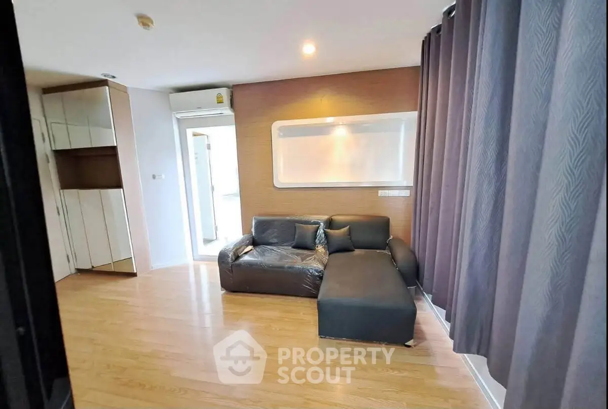 Spacious living room with modern sofa and wooden flooring in a stylish apartment.