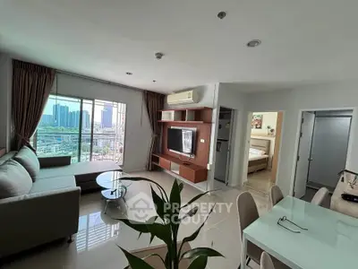 Spacious modern living room with city view, elegant furniture, and open layout in a high-rise apartment.