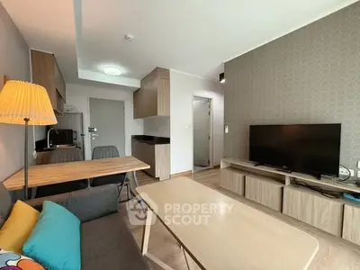 Modern living room with stylish furniture and wall-mounted TV in a cozy apartment.