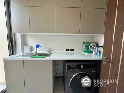 Modern laundry room with sleek cabinetry and washing machine