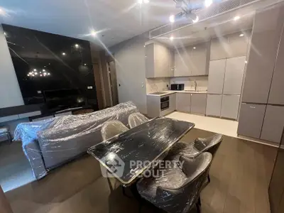 Modern open-plan living room and kitchen with sleek furniture and appliances.