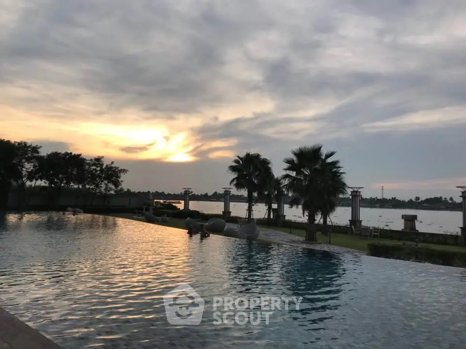 Stunning infinity pool with serene sunset view and lush greenery, perfect for luxury living.