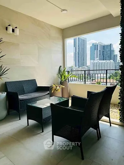 Stylish balcony with modern furniture and city skyline view, perfect for relaxation and urban living.