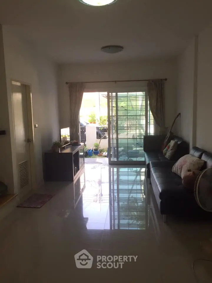 Spacious living room with natural light and balcony access in modern apartment.