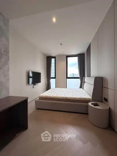Modern bedroom with large windows and minimalist decor in a high-rise apartment.