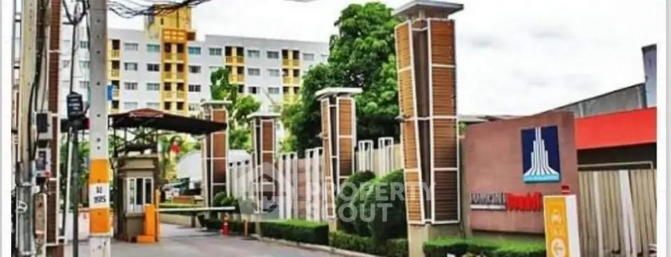Modern apartment building entrance with lush greenery and stylish design.