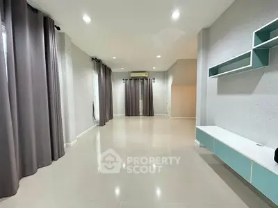 Spacious empty living room with modern design and large windows.