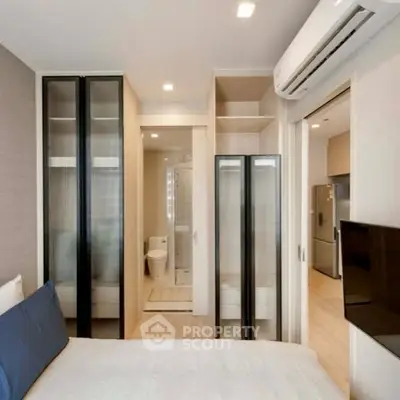 Modern bedroom with ensuite bathroom and sleek storage solutions.