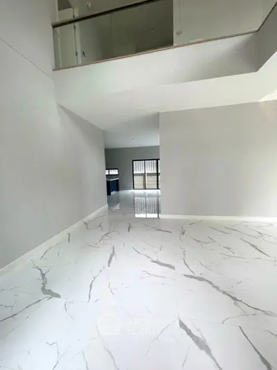Spacious modern interior with marble flooring and large windows, perfect for luxury living.