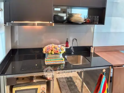 Modern kitchen with sleek black countertops and built-in appliances, featuring a stylish open layout.