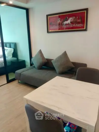 Modern living room with stylish sofa and dining area in open layout apartment.