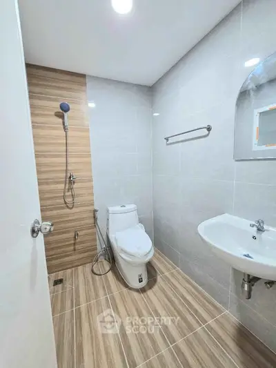 Modern bathroom with sleek fixtures and wood-style tile flooring