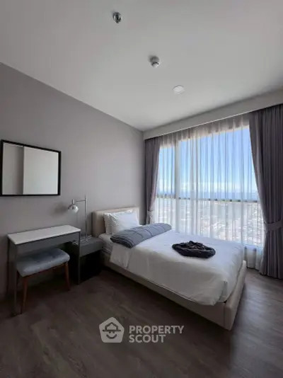 Modern bedroom with large window and stylish decor in high-rise apartment