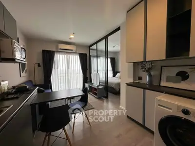 Modern open-plan apartment with stylish kitchen and cozy living area, featuring floor-to-ceiling windows and elegant decor.