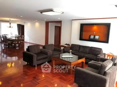 Spacious living room with elegant wooden flooring and modern furniture in a luxurious apartment.