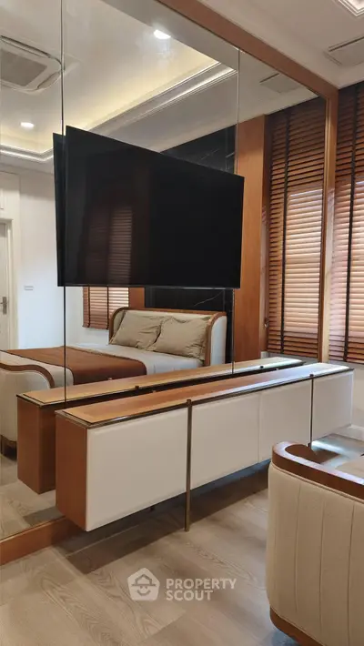 Modern living room with sleek design, featuring a wall-mounted TV and stylish wooden accents.