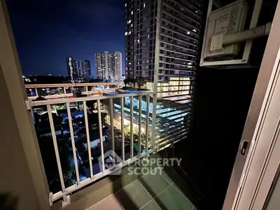 Stunning night view from a modern balcony overlooking cityscape with high-rise buildings.