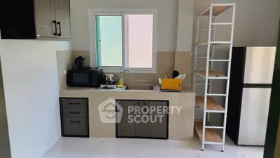 Modern kitchen with sleek cabinetry, stainless steel appliances, and ample shelving space.