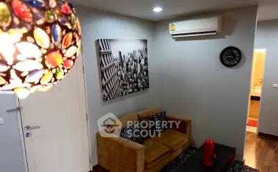 Stylish living room with modern decor and vibrant lighting, featuring a cozy sofa and wall art.