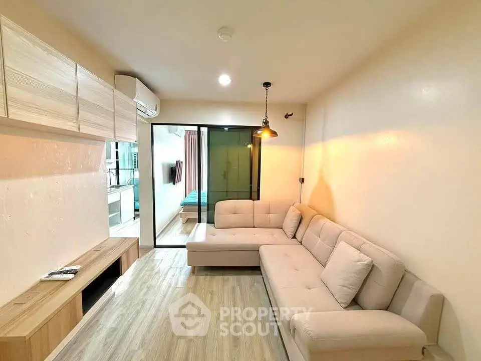 Modern living room with cozy beige sofa and stylish lighting in a contemporary apartment.