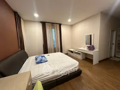 Spacious bedroom with modern decor and wooden flooring