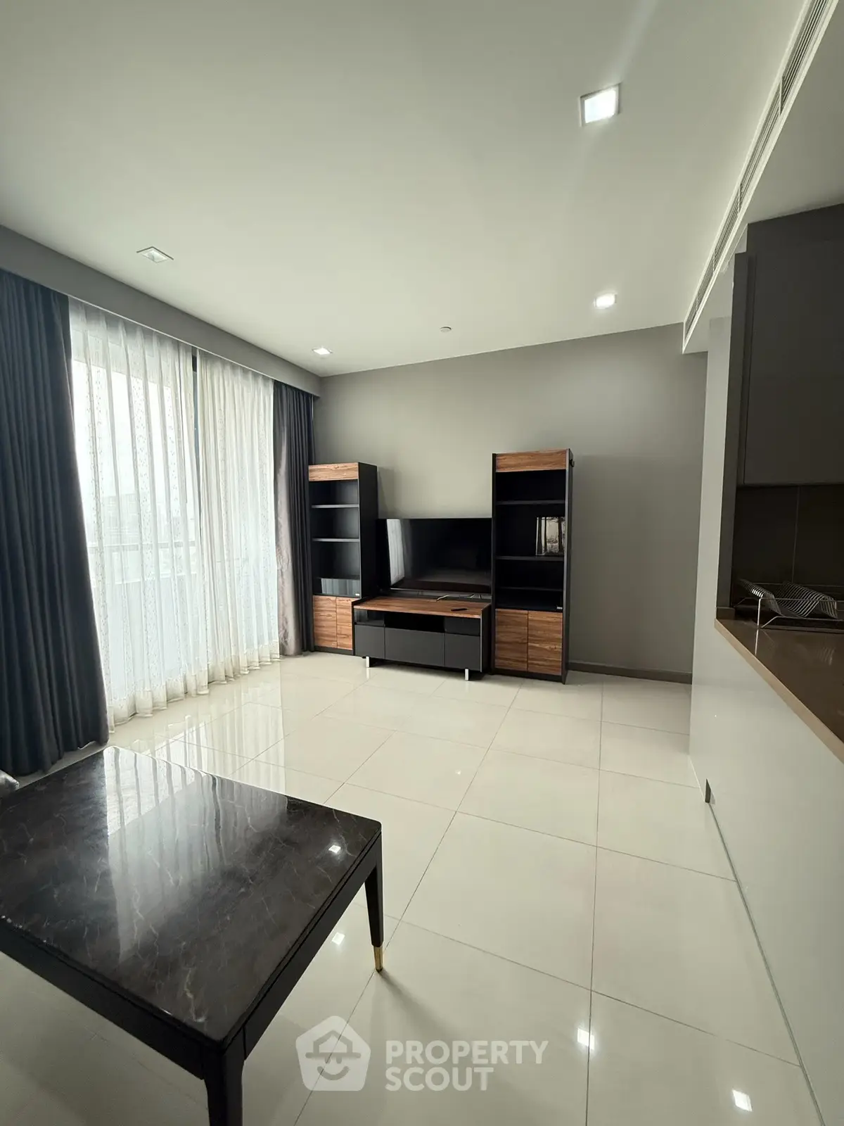 Spacious modern living room with sleek furniture and large windows for natural light.