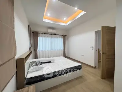 Spacious modern bedroom with elegant lighting and wooden flooring