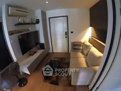 Cozy living room with modern decor and wall-mounted TV in stylish apartment.
