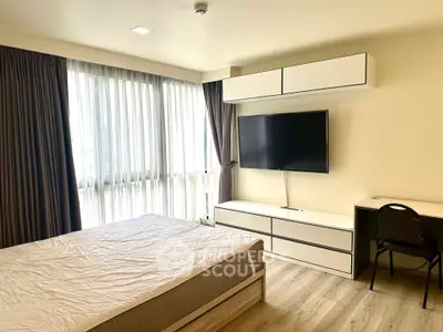 Spacious modern bedroom with large window and sleek furnishings