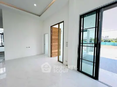 Spacious modern interior with large windows and sliding doors, ideal for natural light.