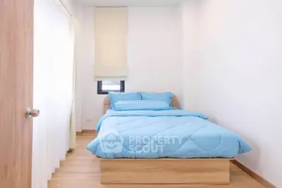 Cozy minimalist bedroom with natural light and wooden flooring