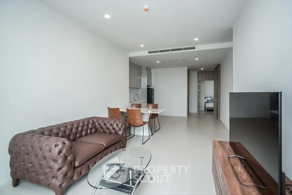 Modern living room with elegant brown leather sofa and sleek glass coffee table