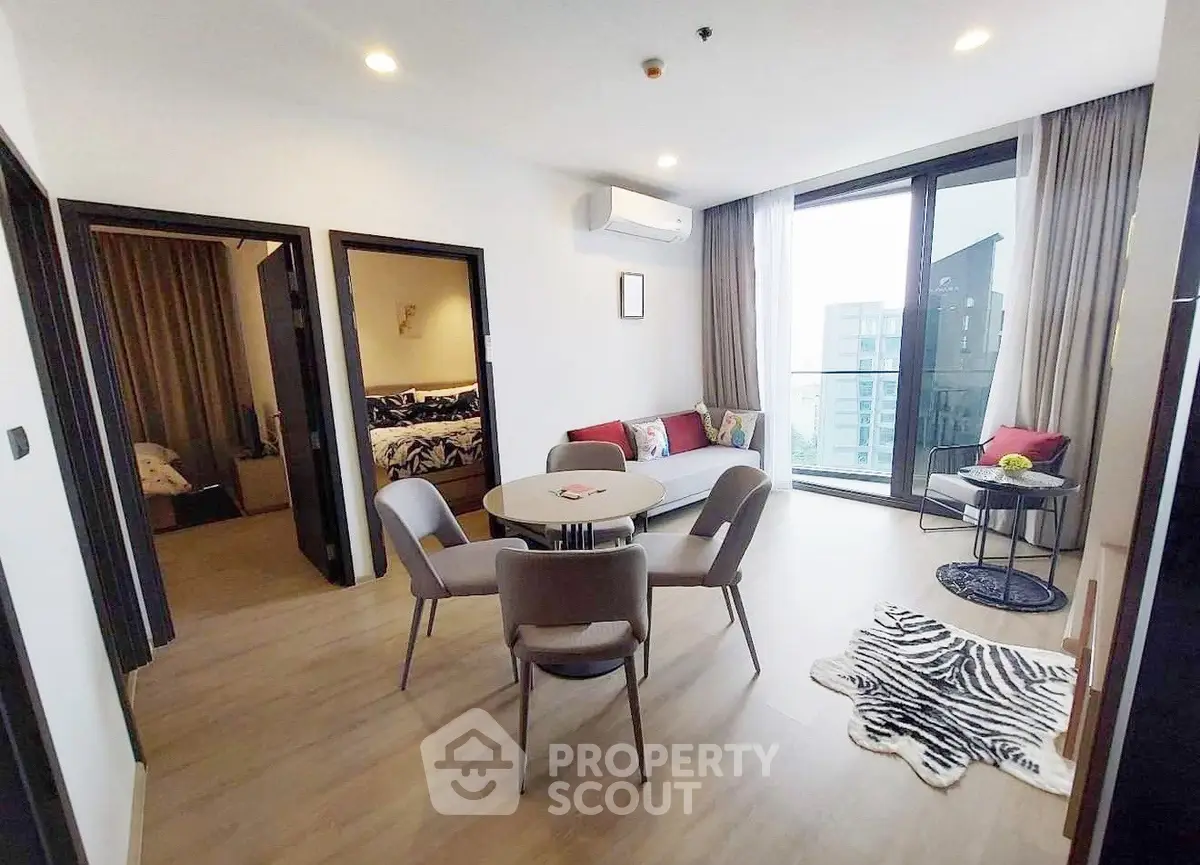 Modern living room with dining area and balcony view in a stylish apartment