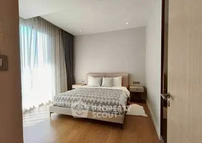 Spacious bedroom with elegant decor and large window for natural light