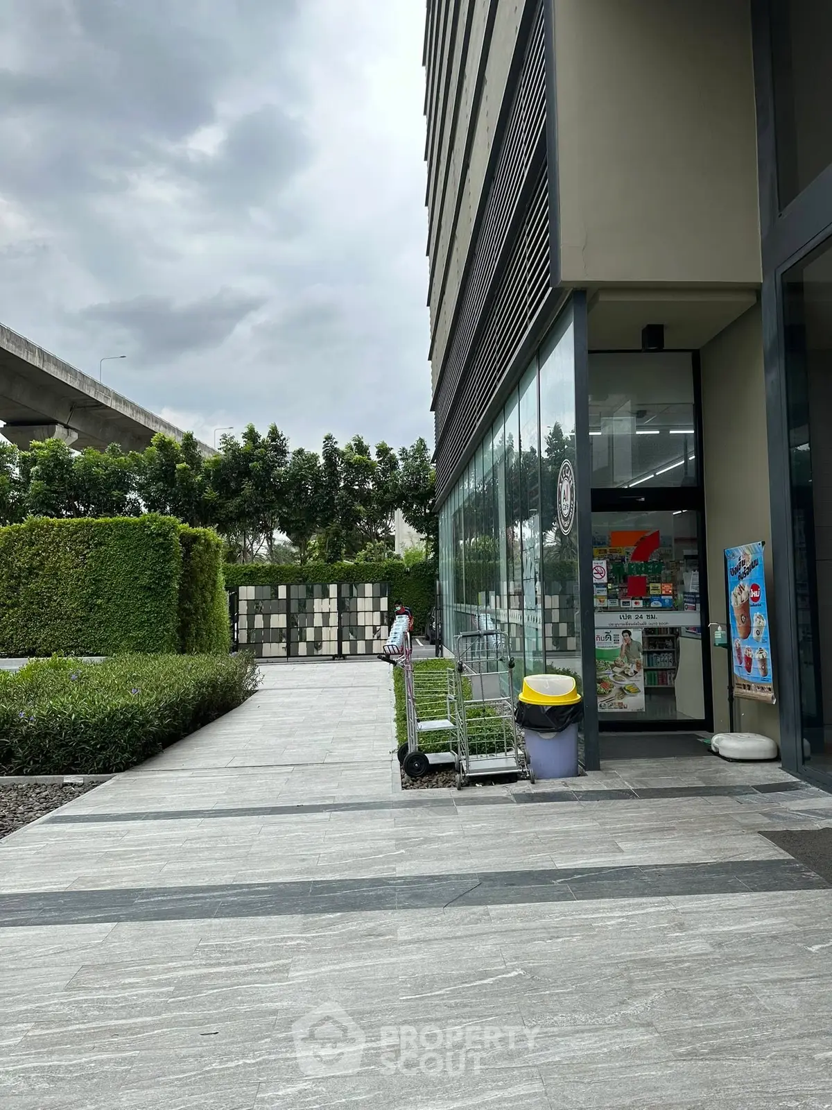 Modern building exterior with glass facade and landscaped walkway, ideal for commercial real estate investment.