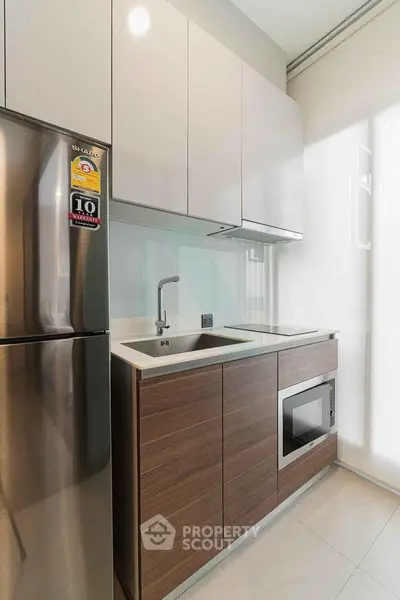 Modern kitchen with sleek cabinetry and built-in appliances in a compact layout.