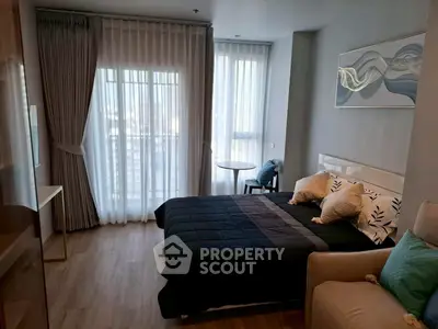 Modern bedroom with large windows and stylish decor in a high-rise apartment.