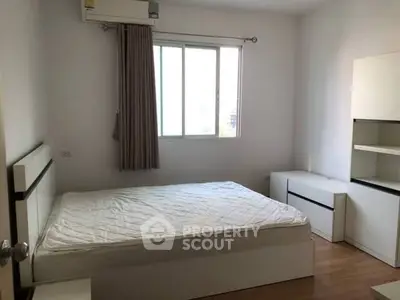 Spacious bedroom with natural light and modern furnishings