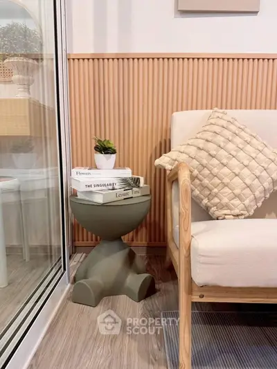 Cozy modern living room corner with stylish chair and side table, perfect for relaxation.