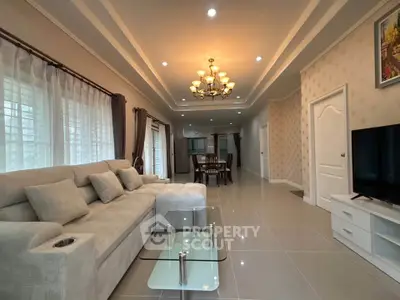 Spacious living room with elegant chandelier and modern furniture in a stylish home.