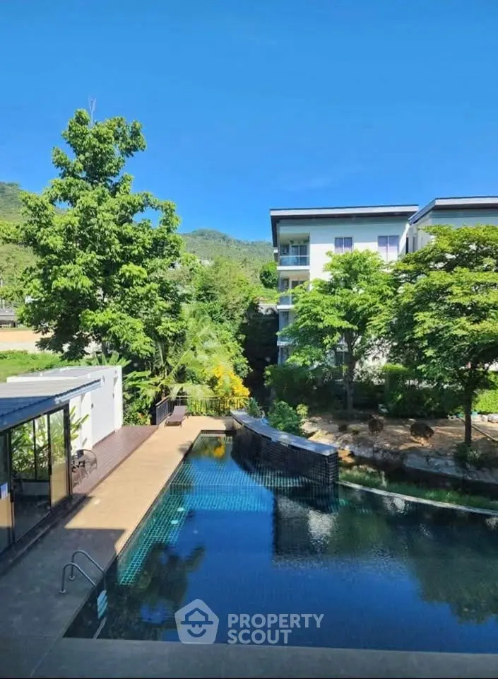 Stunning poolside view with lush greenery and modern apartment building.