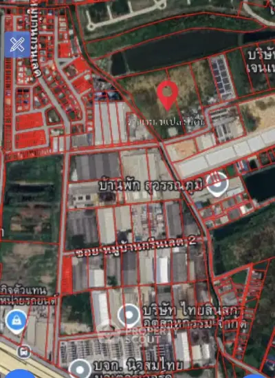 Aerial view of a residential and commercial area with plotted land and buildings.