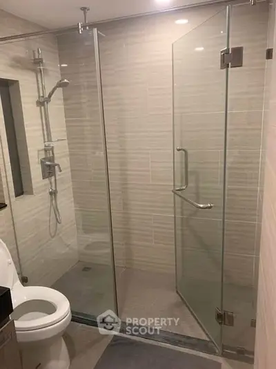 Modern bathroom with glass shower enclosure and sleek fixtures.