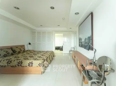 Spacious bedroom with modern decor and ample natural light in a stylish apartment.