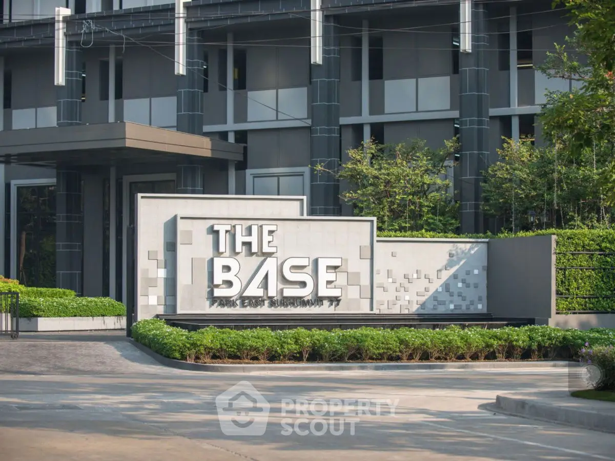 Modern condominium entrance with sleek design and lush greenery