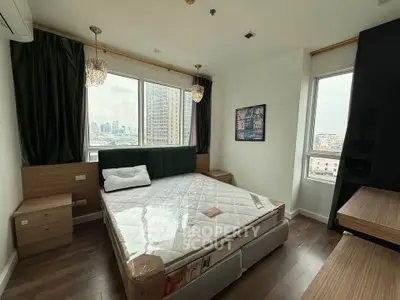 Modern bedroom with city view, stylish decor, and natural light