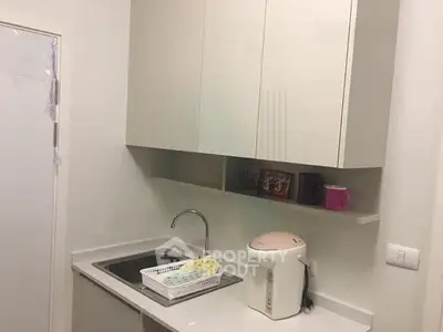 Compact kitchen with sleek cabinets and modern sink in a cozy apartment.