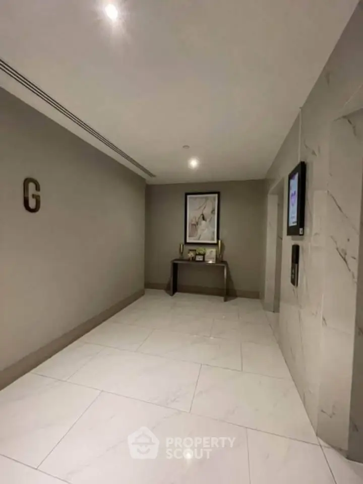 Elegant building lobby with modern decor and marble flooring, showcasing a sophisticated entrance area.