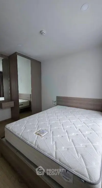 Modern bedroom with minimalist design and large mirror wardrobe