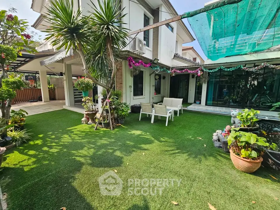 Charming garden view of a modern home with lush greenery and cozy outdoor seating.